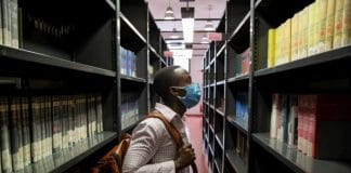 Jules, a 26-year-old student from the Democratic Republic of the Congo, scans the shelves of the social science library at the University of Florence