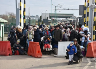 rifugiati aspettano i convogli che li escorteranno in aree sicure