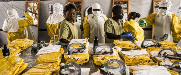 Gli operatori sanitari indossano dispositivi di protezione individuale (DPI) prima di entrare in una zona di quarantena Ebola nella Repubblica Democratica del Congo.