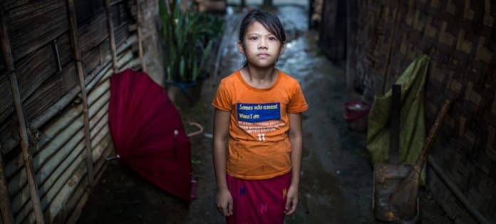 Una bambina fuori dalla sua casa, in un campo sfollati in Myanmar.