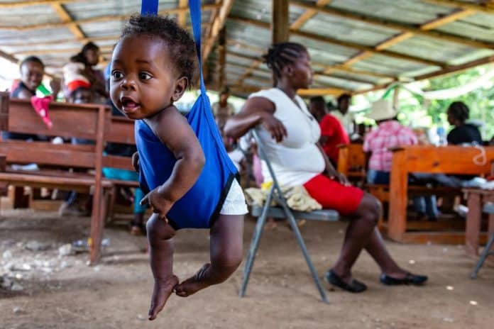 A child is weighed before receiving multiple vaccines at an outreach clinic near Camp-Perrin, Haiti.