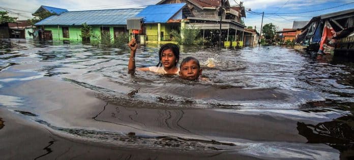 Bambini nuotano dopo un alluvione