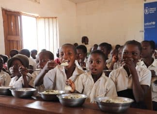 In questa foto i bambini mangiano il pranzo a scuola
