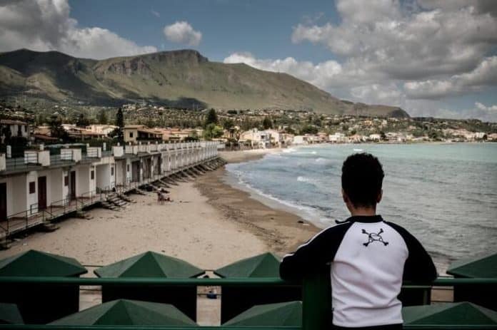 Un ragazzo che ha chiesto asilo come minore non accompagnato guarda la spiaggia di Trabia, in Italia. 14 maggio 2016