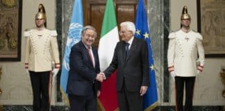 Guterres stringe la mano al Presidente Mattarella davanti alle bandiere dell'ONU, UE e italiana