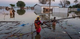 una donna e un bambino sudsudanesi cercano di recuperare i propri averi dopo un alluvione