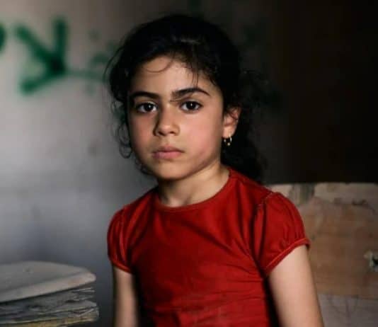Tabarak, 6 anni, Iraq. Tabarak vive nel quartiere occidentale della città vecchia di Mosul, devastato dalla guerra. Siede in un'aula vuota della scuola elementare Al-Ekhlas, nel quartiere di Nabi Jarjis.