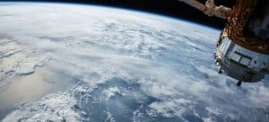 Una veduta della Terra e di un satellite visti dallo spazio.