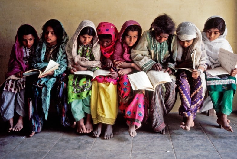 girls reading on a bench © UN Photo | John Isaac