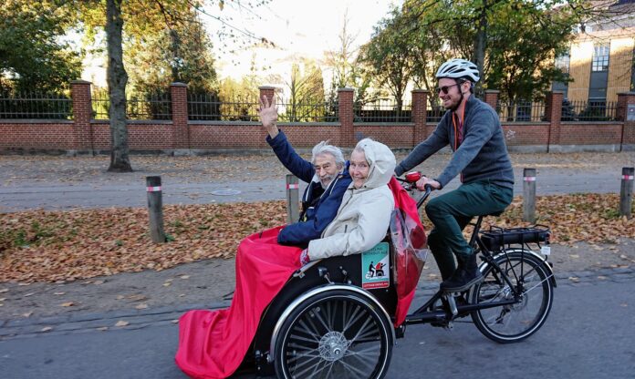 Twee passagiers op een ritje met de riksja als deel van het Fietsen Zonder Leeftijd © Cycling Without Age