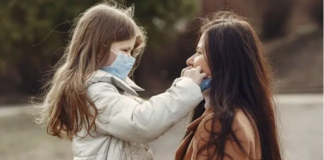 Moeder en dochter dragen mondmasker tegen COVID-19