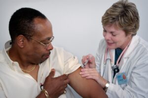Mann blir vaksinert av lege