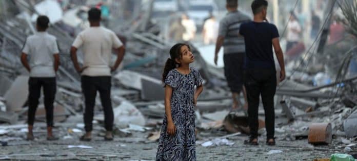 Jente står å ser i byen som er blitt bombet