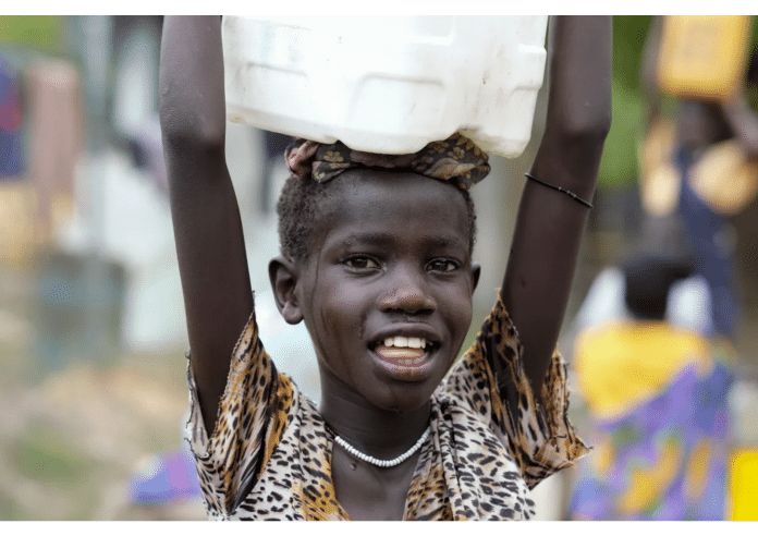 Sandy Chuol, 10, på vei hjem med en dunk med rent vann som hun har hentet ved en UNICEF-støttet vannpost i den krigsherjede byen Malakal i Sør-Sudan. Foto: UNICEF/UN0215532/Rich