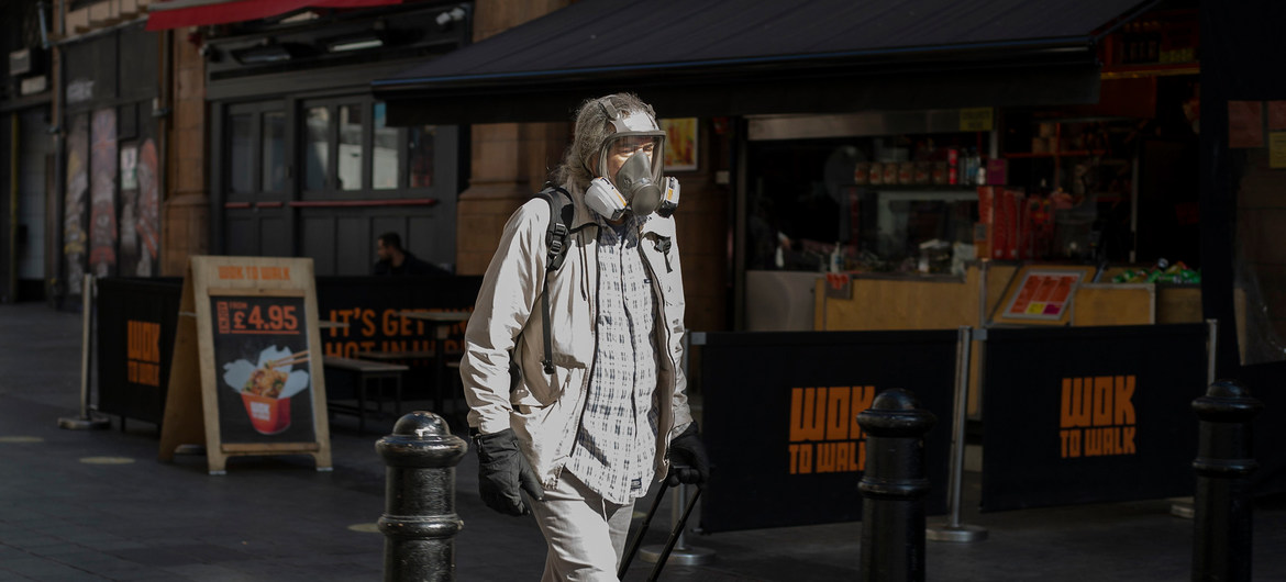 Um homem caminha com máscara para se proteger do coronavírus 