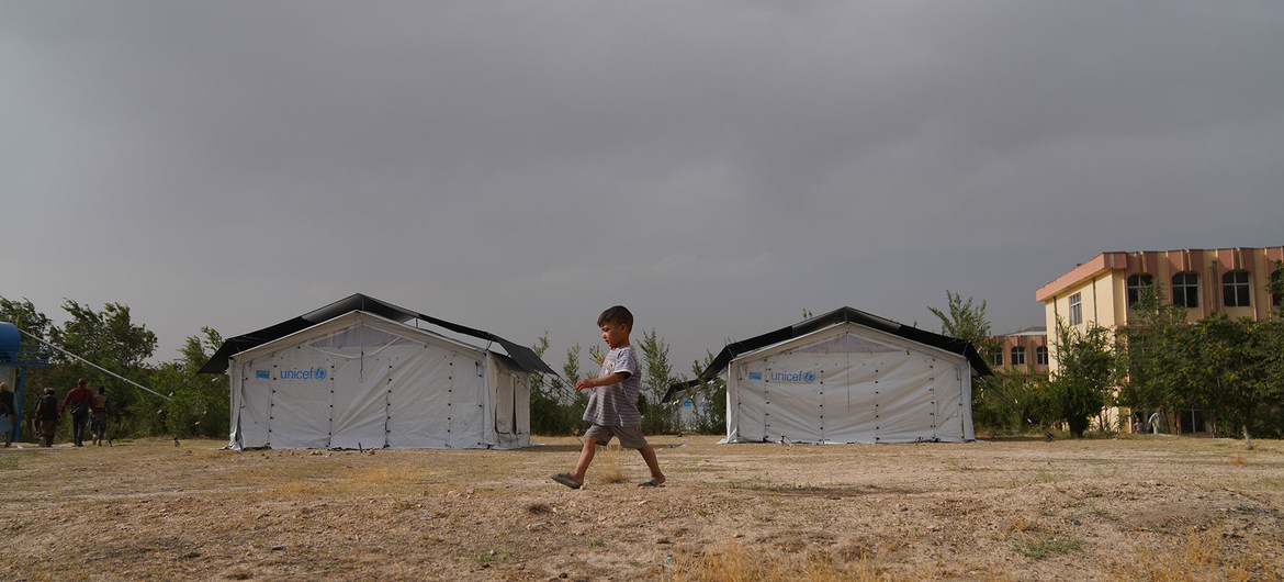 Uma criança caminha por um campo temporário montado em Cabul depois que sua família foi deslocada devido à insegurança em todo o Afeganistão