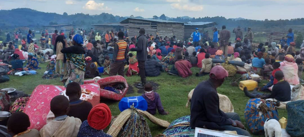 Um grupo de requerentes de asilo congoleses espera no ponto de fronteira, após cruzar para o Uganda devido aos conflitos
