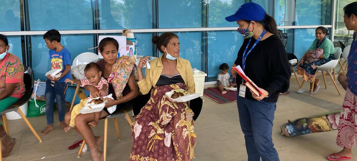 Funcionária da OIM fala com pessoas afetadas pelas enchentes em Timor-Leste