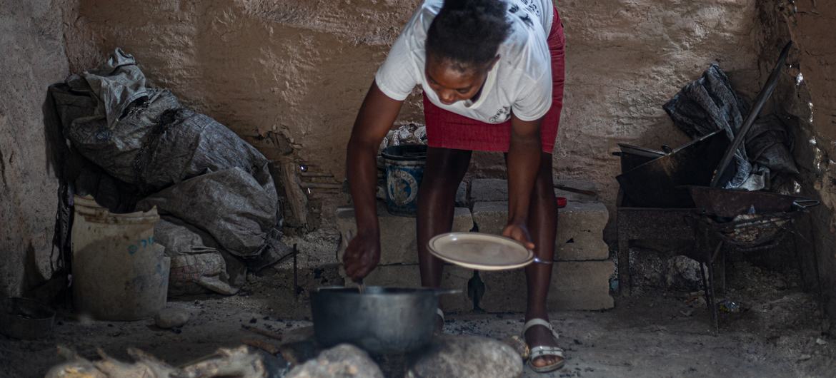 Mulher prepara refeição no Haiti. 