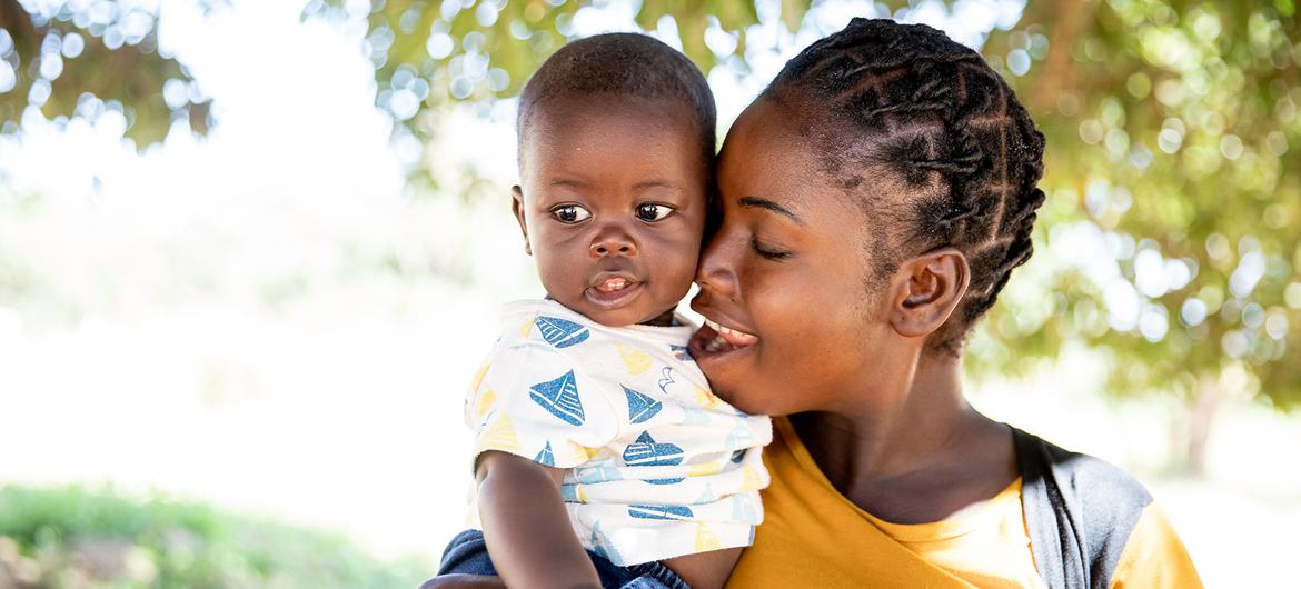 Uma mãe leva seu bebê de seis meses para um exame de saúde em uma clínica em Chipata, Zâmbia