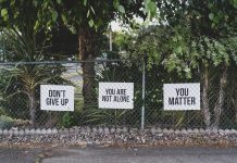Stängsel med skyltar där det står "ge inte upp", "du är inte ensam", "du är av betydelse".