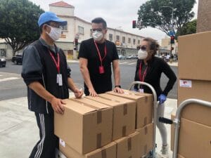 Tre människor med masker levererar paket