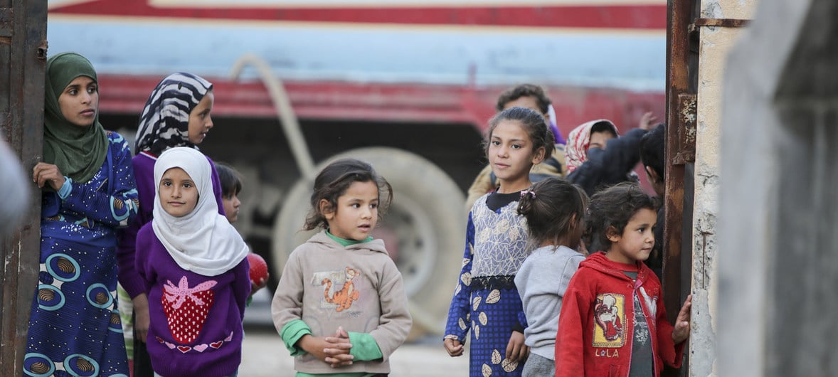 Barn står utanför ett tält som fungerar som en tillfällig skola i Ar-Raqqa, Syrien.