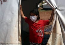Barn med masken mot COVID-19 i lägret i norra Syrien