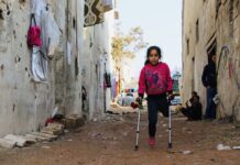 Flicka med ett ben på kryckor i Syrien