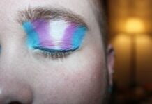 Person som blundar och har transflaggad målad på ögonlocket