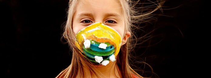 flicka med munskydd mot kol