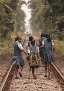 En grupp skolflickor promenerar längs en järnvägsräls