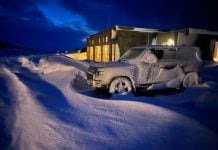 Ett snöigt landskap med en översnöad bil