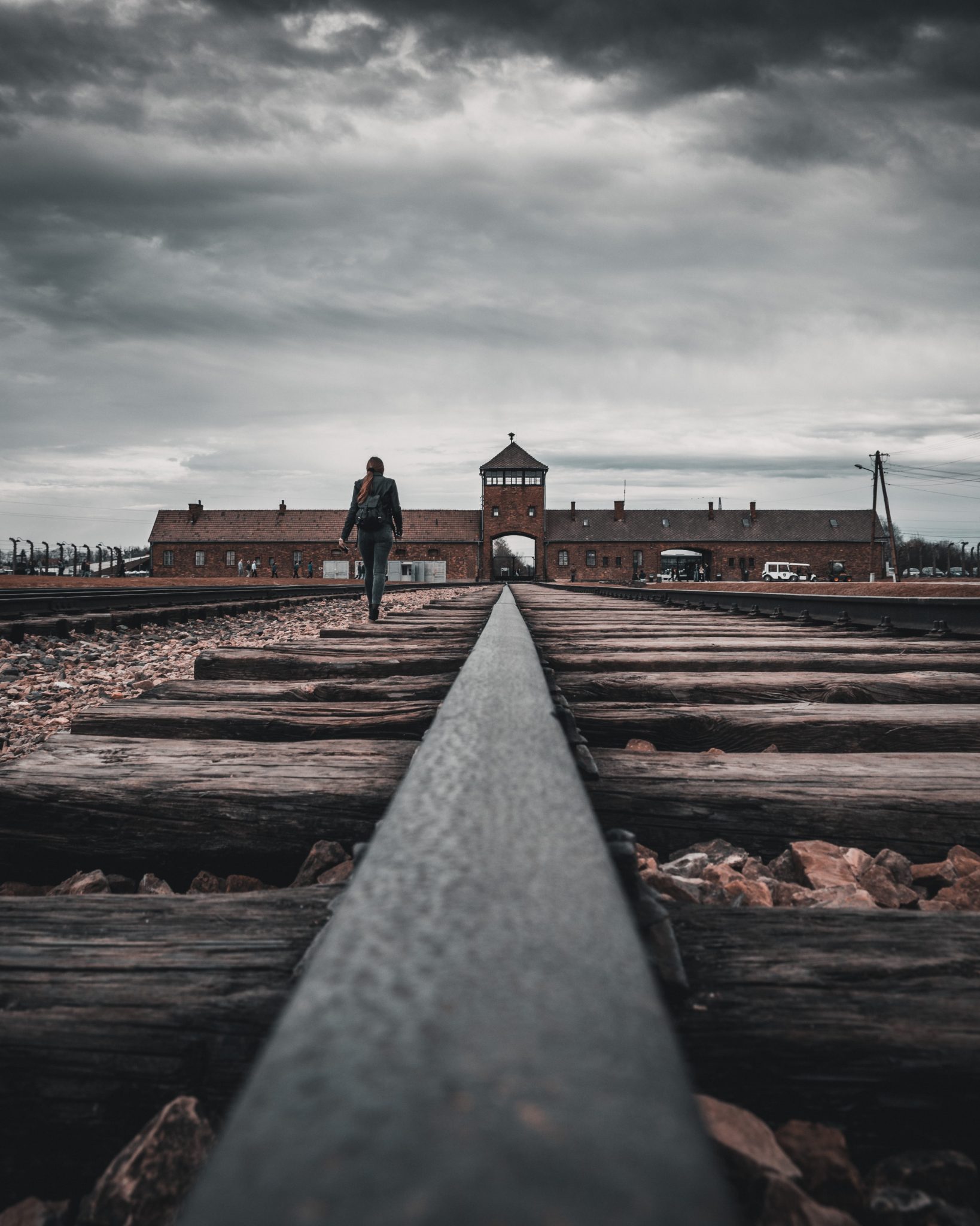 Förintelselägret Auschwitz sett i silhuett med långt perspektiv framifrån.
