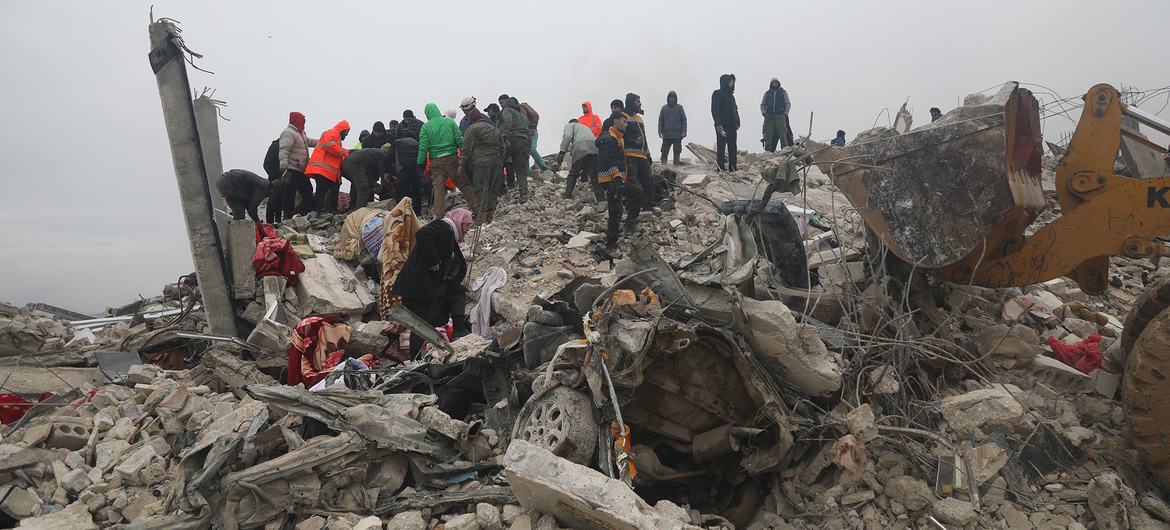 Räddningsarbetare bland hus som förstörts av jordskalvet.