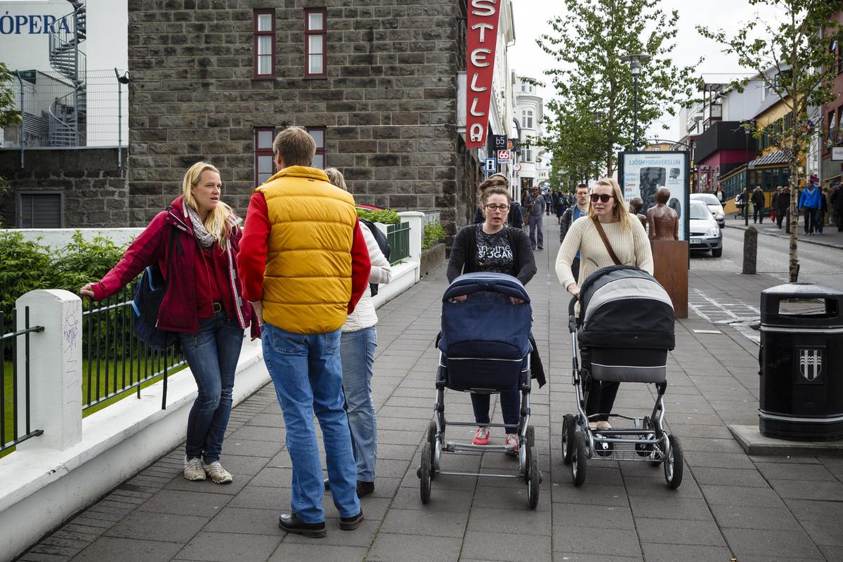 En gatumiljö som innefattar två kvinnor som går med barnvagn.