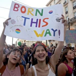 Två kvinnor i ett demonstrationståg som håller en skylt där det står Born This Way