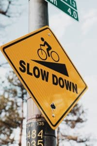 En gul trafikskylt med texten Slow down