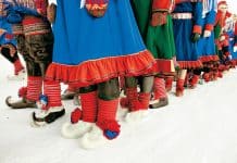 Urbefolkning i traditionell klädsel på mark täckt av snö