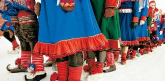 Urbefolkning i traditionell klädsel på mark täckt av snö