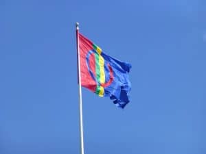 Samernas flagga som vajar mot blå himmel
