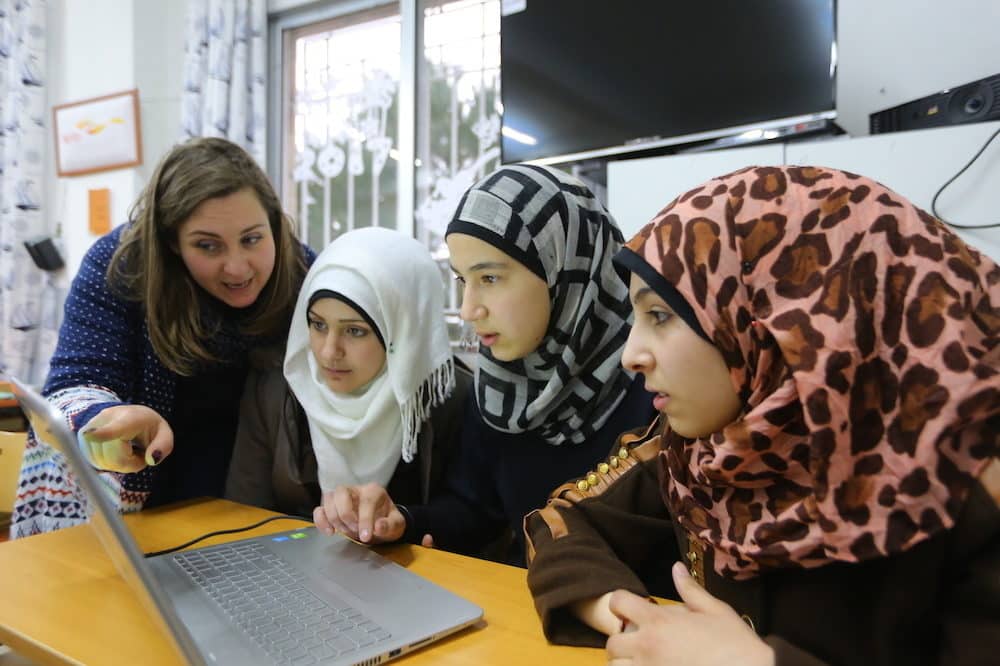 Fyra flickor som samlats kring en dator
