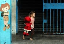 En flicka som springer med en docka i famnen
