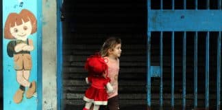 En flicka som springer med en docka i famnen