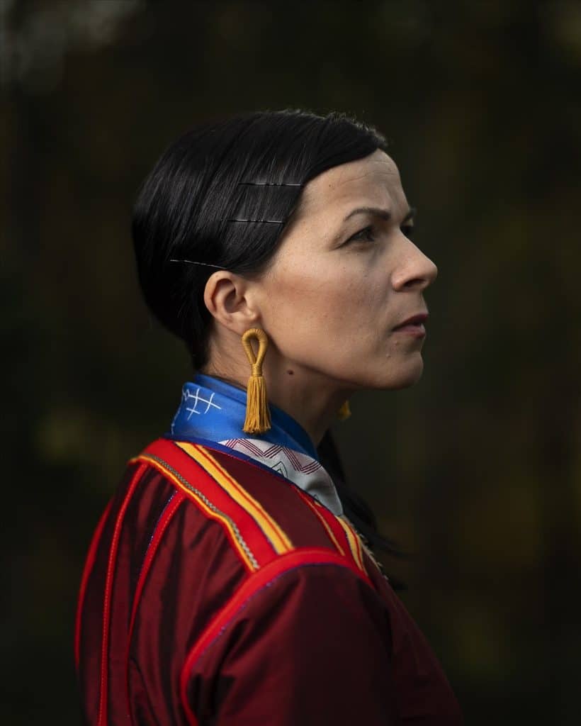 En kvinna i traditionell samisk klädsel som tittar framåt