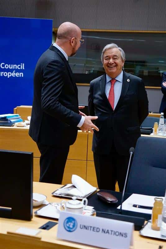 Two men talking in an official setting, one is laughing