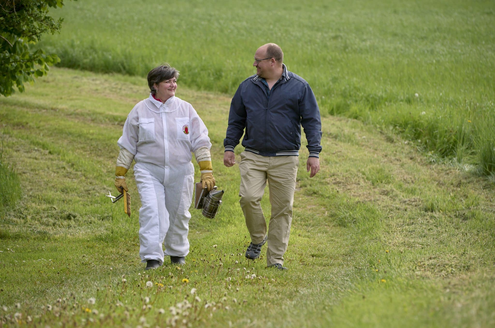 En man och en kvinna som promenerar tillsammans på en gräsmatta